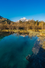 Sunrise view of Zelenci National Park and Nature reservation in Slovenia, Julian Alps. Sunset or sunrise over an alpine lake with blue water and sky. Alpine mountain landscape, river and lake.