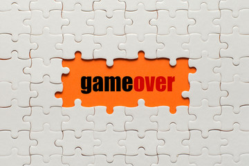 White details of puzzle on orange background and text Game Over