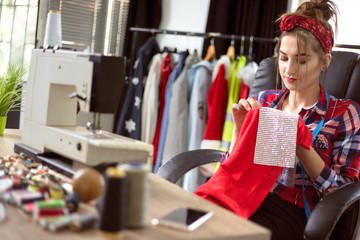 Young seamstress woman using sewing machine to design clothes