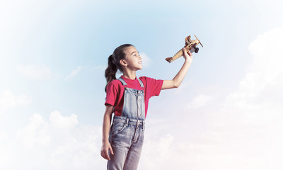 Concept of careless happy childhood with girl dreaming to become