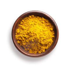 curry powder in a wooden bowl, isolated on white