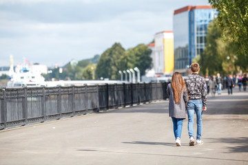 couple is walking along the embankment in the city