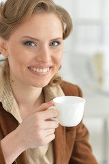 Close-up portrait of a beautiful woman holding cup