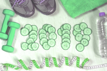New Year's collage, dumbbells and sneakers, sports and a healthy lifestyle, figures from cucumber