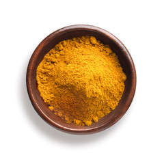 turmeric in a wooden bowl, isolated on white