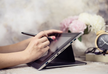 Hand hold digital pen drawing on tablet screen