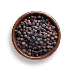 juniper berries in a wooden bowl, isolated on white