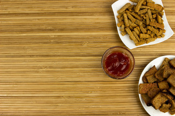 Snacks on a plate. Wooden table. Salty food for beer
