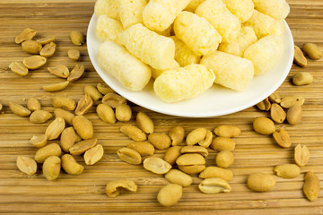corn and nuts  on a plate. Wooden table. Salty food for beer