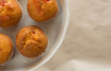 Fresh muffins on a white cake stand. Top view