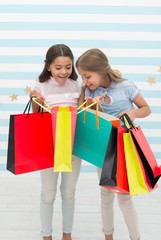 black friday at school market. happy small kids girls with shopping bags after black friday sale. small kids with purchase from school market.