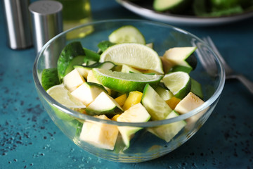 Bowl with tasty vegetable salad on green table