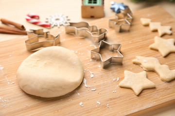 Raw dough for Christmas cookies on wooden board, closeup