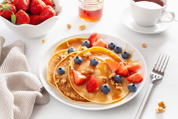pancakes with blueberry strawberry honey and nuts for breakfast