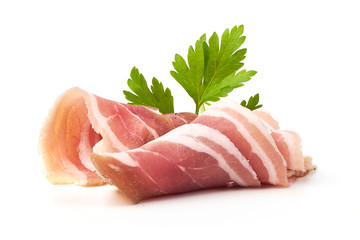 Twisted pieces of pork farmer meat or bacon with parsley, isolated on white background.