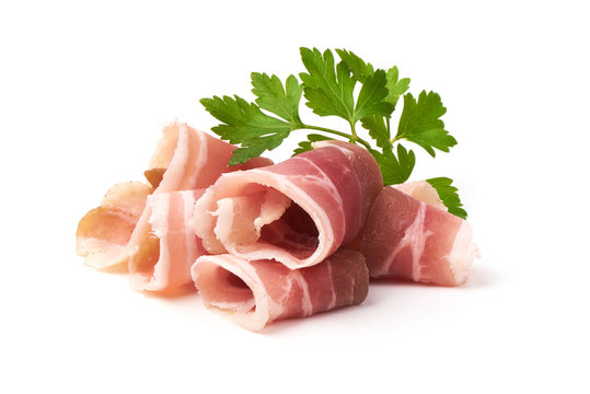 Twisted pieces of pork farmer meat or bacon with parsley, isolated on white background.