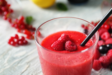Glass with tasty raspberry smoothie on table, closeup