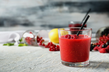 Glass with tasty raspberry smoothie on wooden table