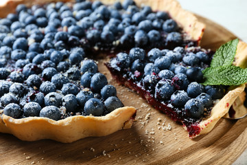 Delicious blueberry pie on wooden board, closeup