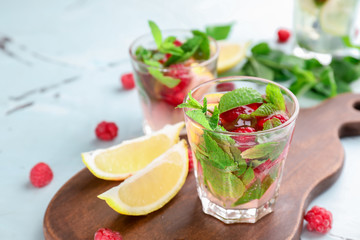 Glass of fresh raspberry mojito on wooden board