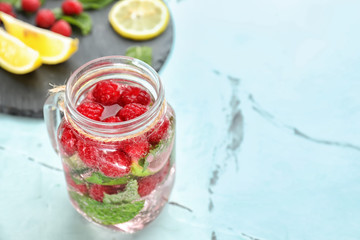 Mason jar of fresh raspberry mojito on light table