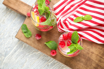 Glasses of fresh raspberry mojito on wooden board