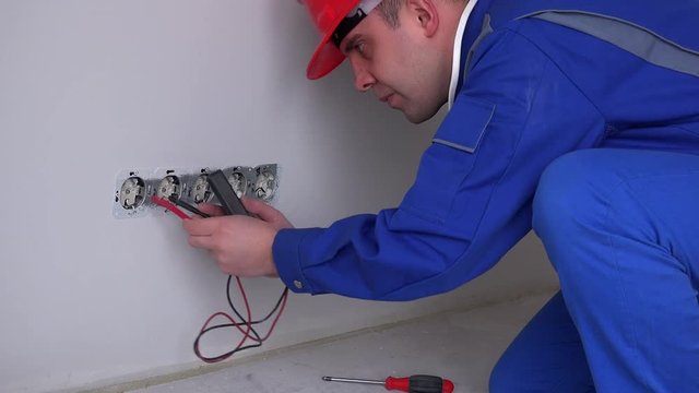 Caucasian worker testing wall socket