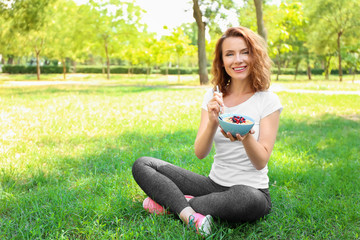 Fototapeta premium Woman eating tasty oatmeal outdoors