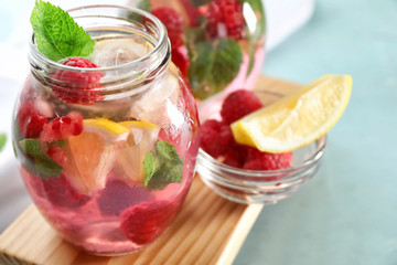 Fototapeta na wymiar Glass jar of fresh raspberry mojito on board, closeup