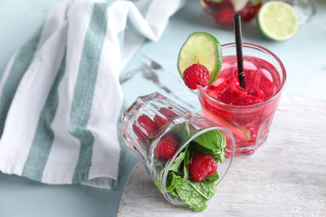 Glasses with fresh mojito and raspberry with mint on board