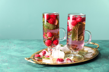 Glasses of fresh raspberry mojito on green table