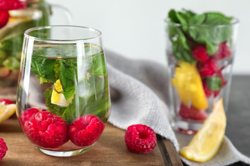 Glass of fresh raspberry mojito on board, closeup