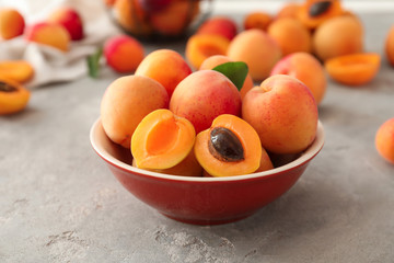 Bowl with ripe sweet apricots on table