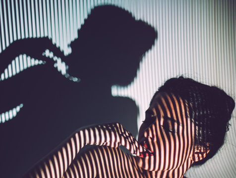 Naked young woman with tattoo lying in studio