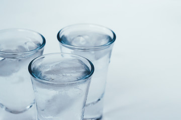 Vodka shots with ice on a white background