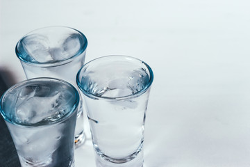 Vodka shots with ice on a white background