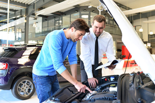 Beratungsgespr&auml;ch im Autohaus zwischen Kunde und Verk&auml;ufer // Consultation at the dealership between customer and seller 