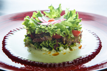 closeup salad with meat and flower topping made from radish