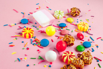 Multicolor, children's, high-calorie, unhealthy candy on a pink background. A table full of sweets.