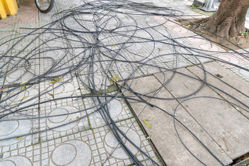 Power cord and Cable power tangled on the Walkway, floor and square drain hose.