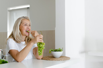 Adult woman eating grape - Powered by Adobe