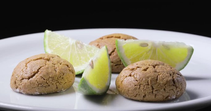 Dolci da pasticceria Amaretti con spicchi di limone su un piatto rotante. Vista macro.