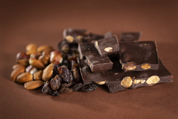 Stack of dark chocolate pieces with roasted almonds and raisins