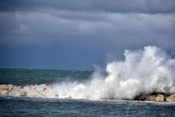 windy day at sea with big waves against rocks