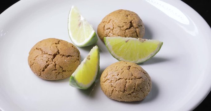 Dolci da pasticceria Amaretti con spicchi di limone su un piatto rotante