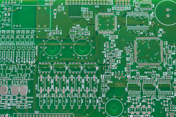 A green computer circuit board background with microcircuits.