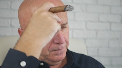 Fototapeta premium Disappointed Businessman Image Smoking a Cigar In Office Room