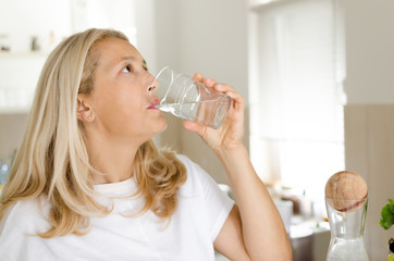 Close up of senior woman drinking a glass of water. Space for text