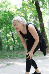 Fototapeta na wymiar Senior woman feeling paing during run