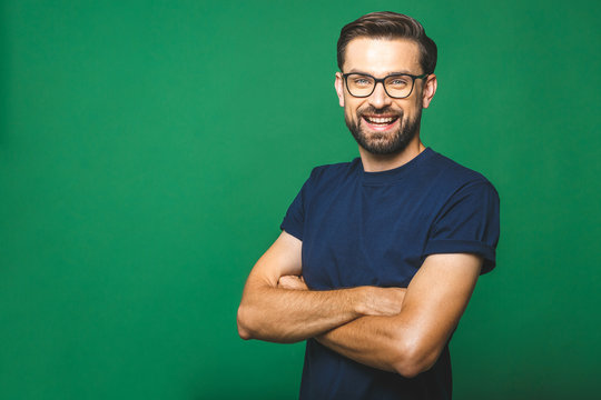 A portrait of young handsome man in casual isolated on green background with glasses.